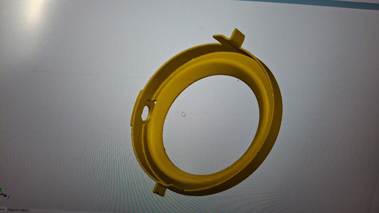 Yellow 3D representation of a ring-shaped component with a central opening, side hole and projecting tabs