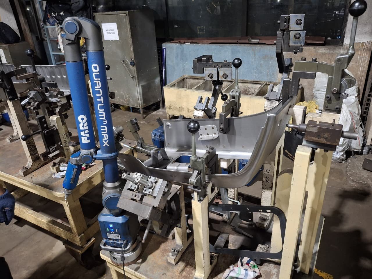 FARO Quantum Max portable CMM beside a sheet-metal component held in a checking fixture
