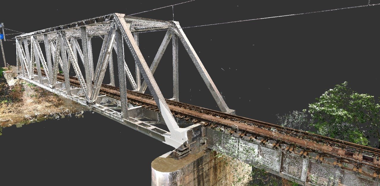 Oblique point-cloud view of a steel truss railway bridge and its approach tracks